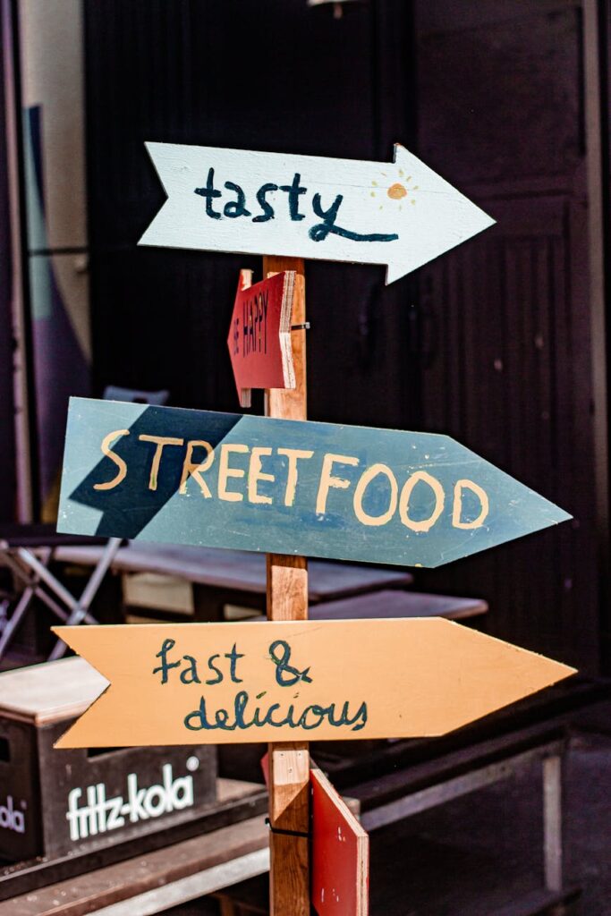 Steaming bowls of char kway teow and colorful hawker stalls lining a historic George Town street in Penang.