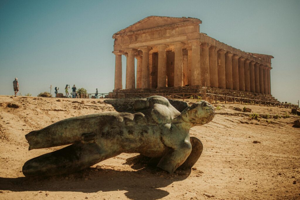 The Temple of Concordia at Agrigento's Valley of the Temples, with a bronze fallen Icarus in the foreground