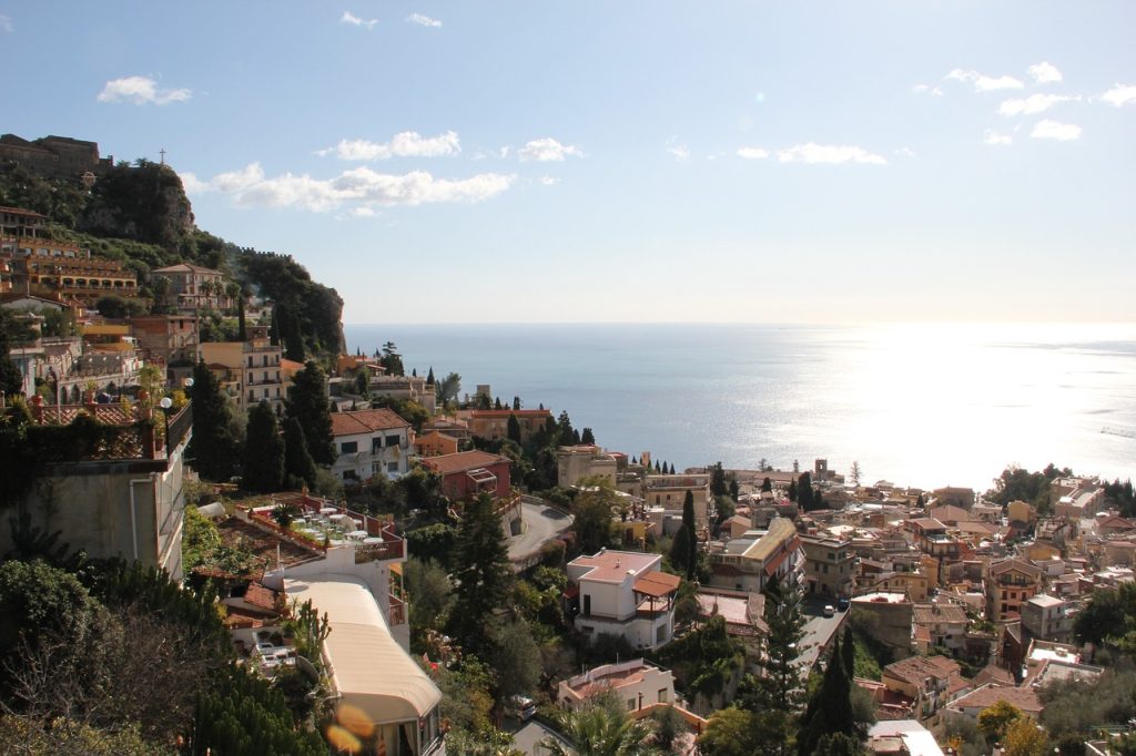 View over Taormina's rooftops to the Ionian Sea, with the Saracen castle on the cliff above
