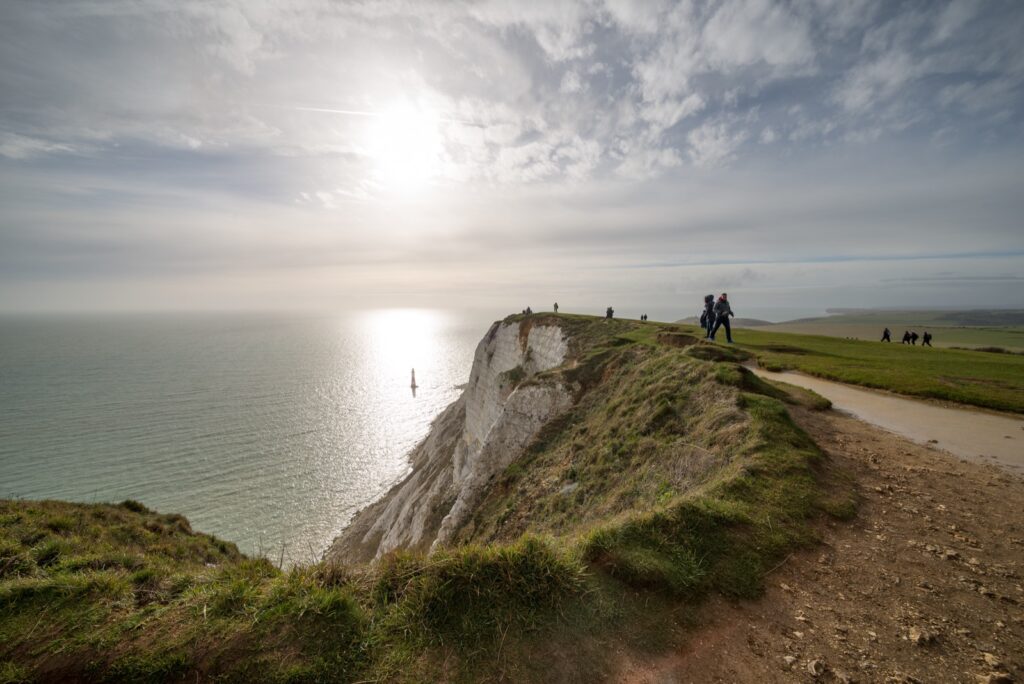 The white chalk cliffs and red-and-white lighthouse at Beachy Head, just outside Eastbourne, rising above the English Channel.