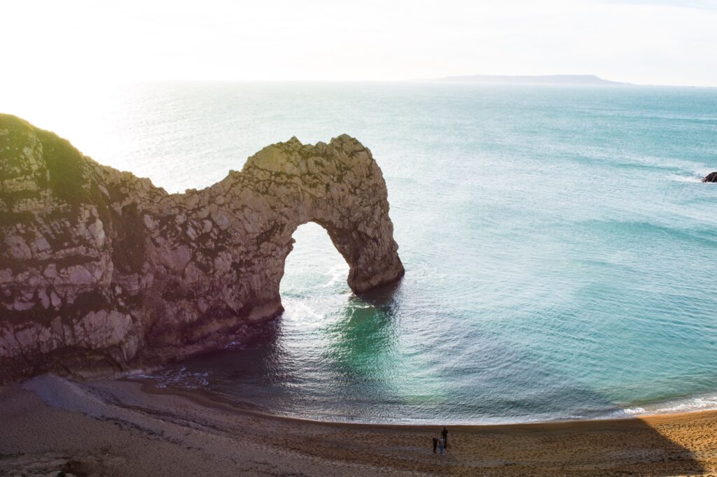 Durdle Door, the natural limestone arch on Dorset's Jurassic Coast, framed by cliffs and sea.