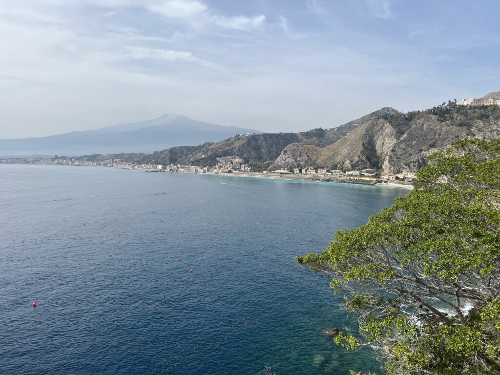 View from Taormina over the bay towards Giardini Naxos with Mount Etna behind
