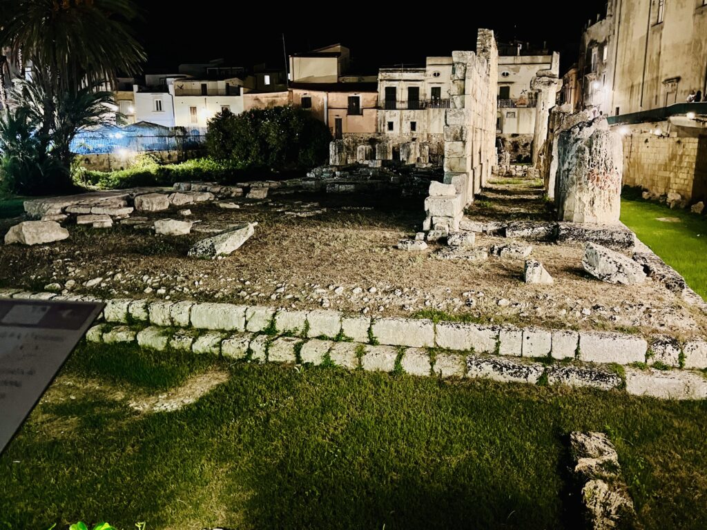 Temple of Apollo ruins floodlit at night in Ortigia, Syracuse