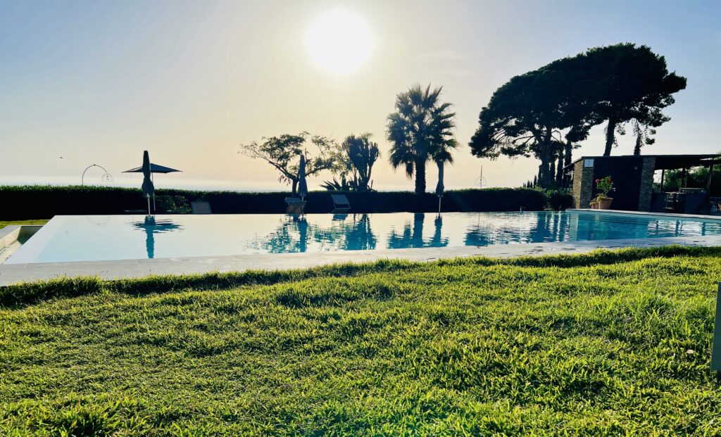 Sunset over the pool and lawns at Masseria del Carboj, Menfi