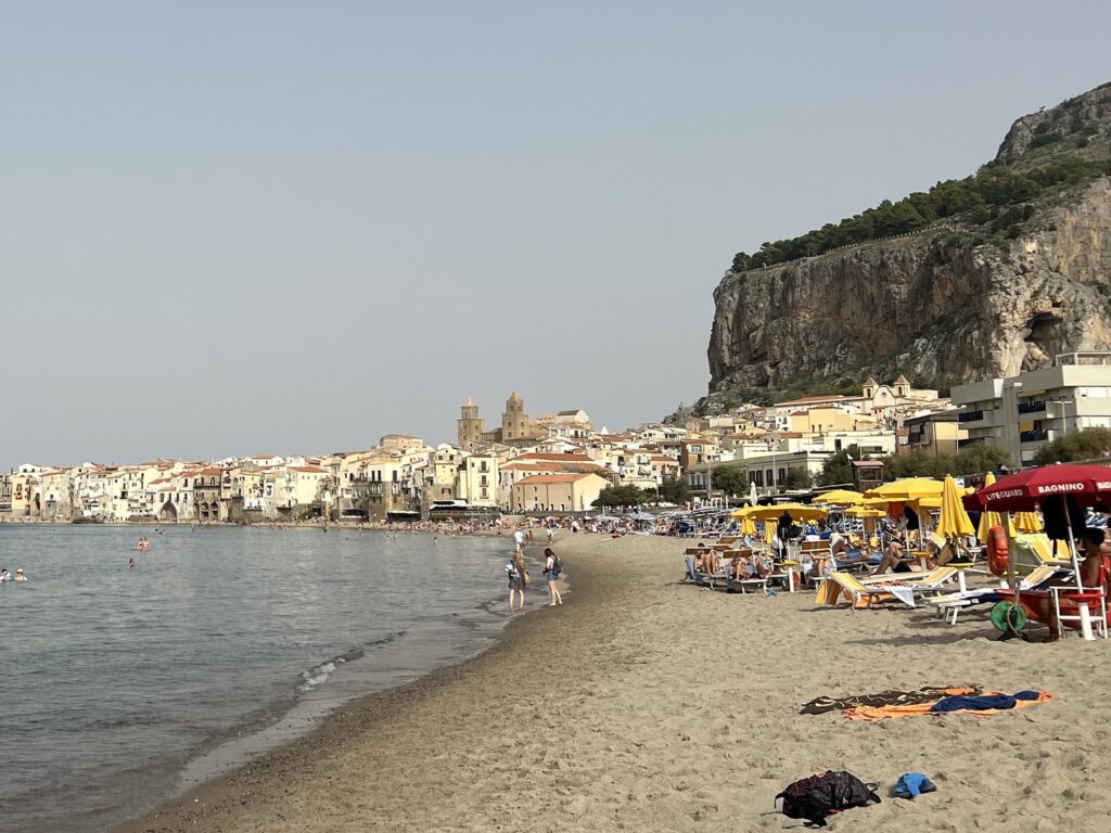 Cefalù beach with the old town, the cathedral towers and the Rocca behind