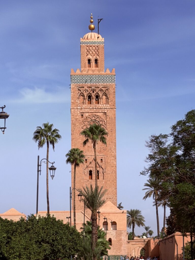 The Koutoubia Mosque minaret rising above palm trees, the first landmark in our Marrakech travel guide