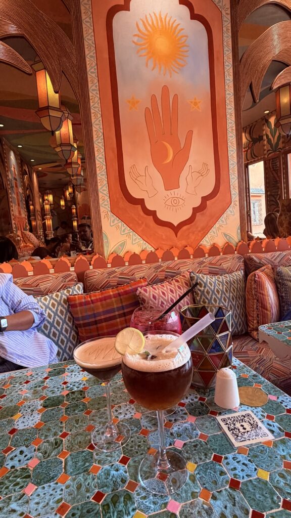 A drink under the hand-of-Fatima mural at MÖ-MÖ rooftop above Jemaa el-Fnaa, Marrakech