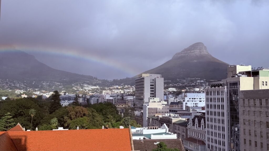 A rainbow arching over Cape Town's city centre and Lion's Head on a showery May morning