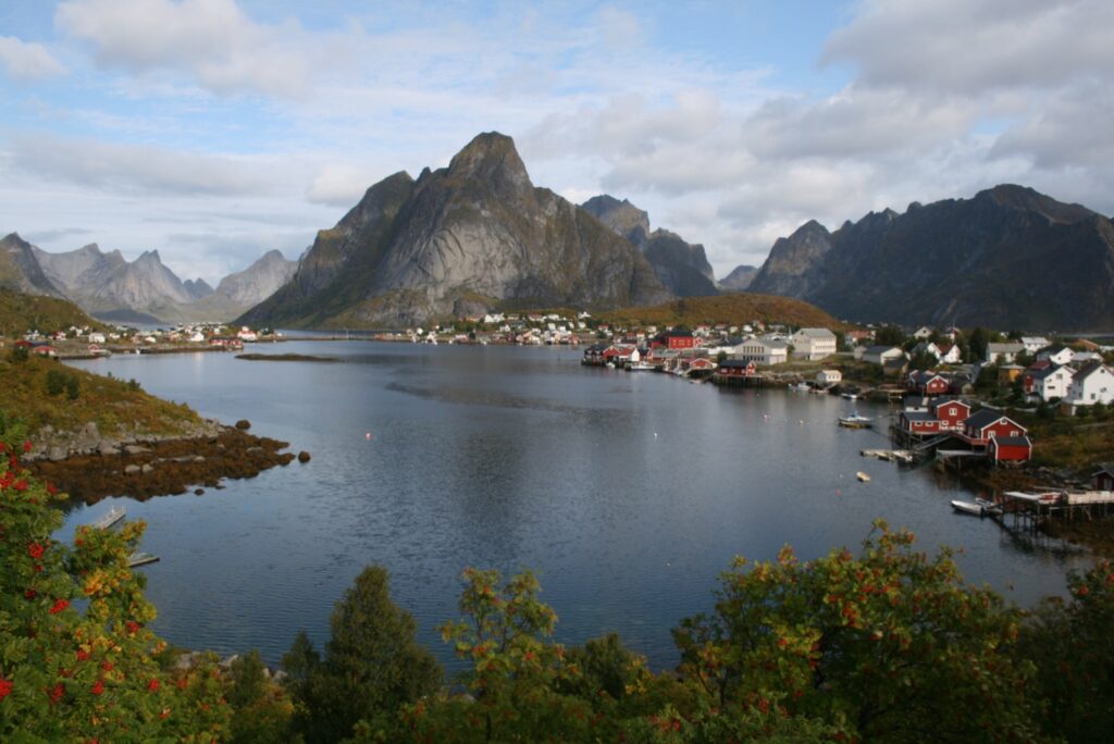 Red fishing cabins and peaks around the harbour at Reine in the Lofoten Islands, Norway